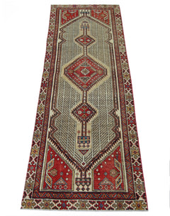 A vintage Persian Serab runner featuring a geometric diamond pattern in red and beige tones.