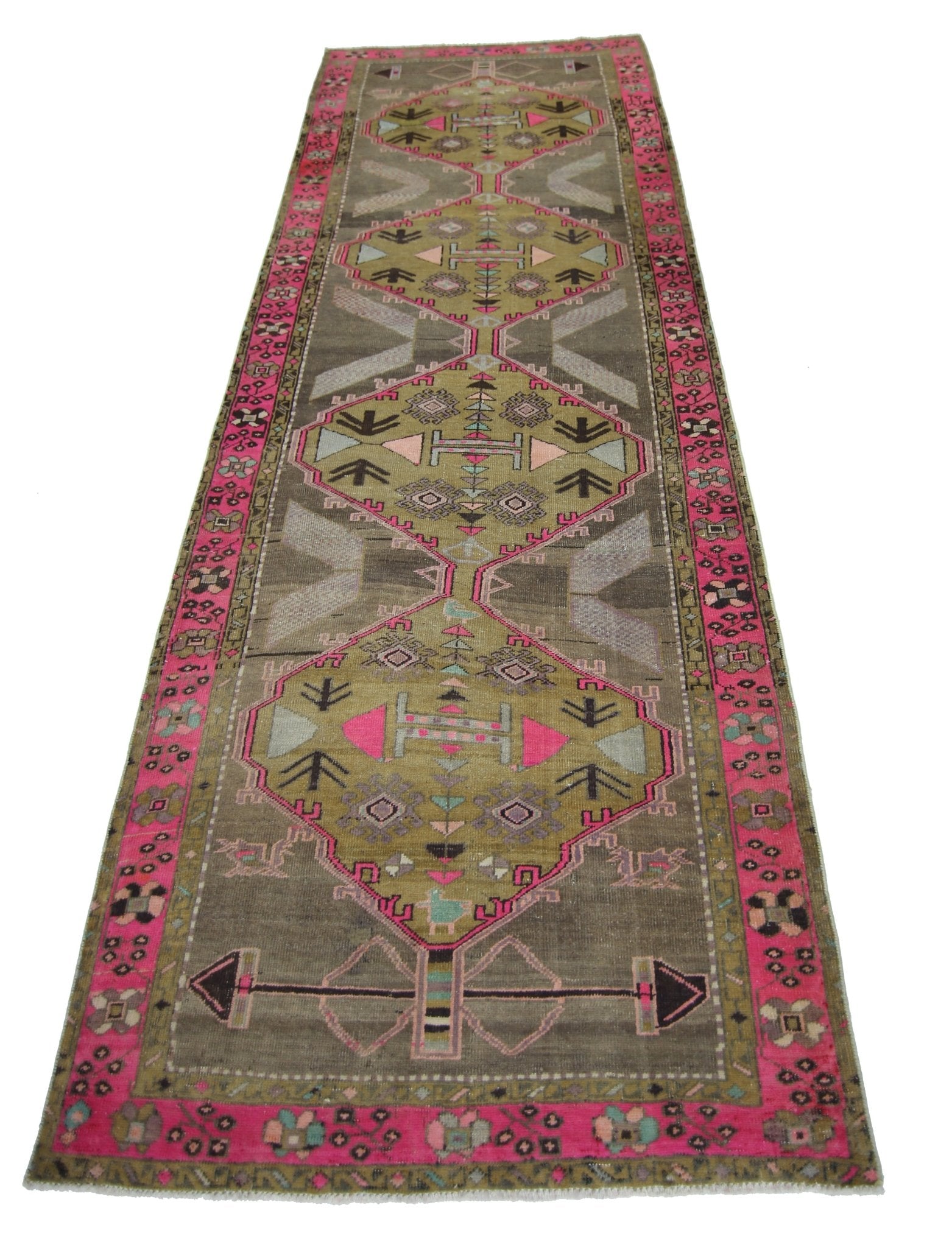 A vintage Persian Serab runner rug featuring geometric patterns in olive, grey, and vibrant pink.