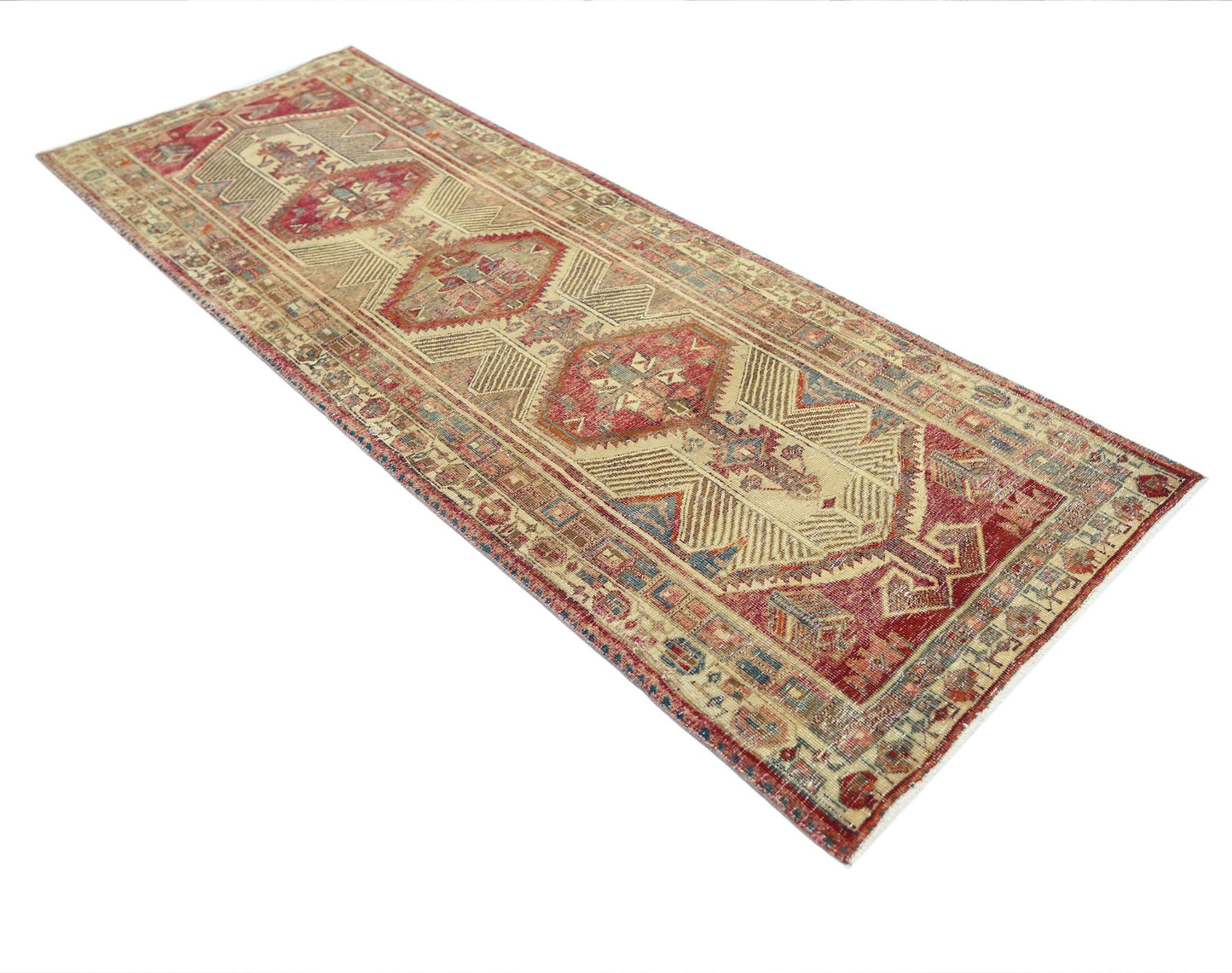 A vintage Persian Serab runner rug featuring geometric medallions in red and beige tones.
