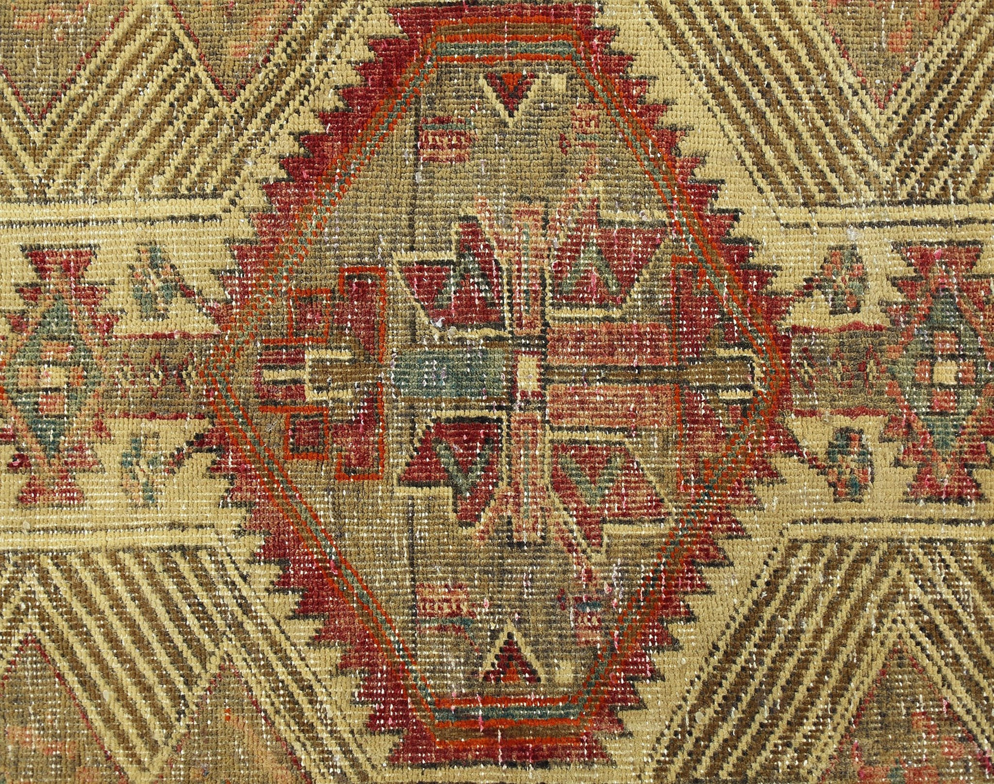 A vintage Persian Serab runner featuring a central geometric medallion in red, green, and tan.