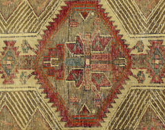 A vintage Persian Serab runner featuring a central geometric medallion in red, green, and tan.