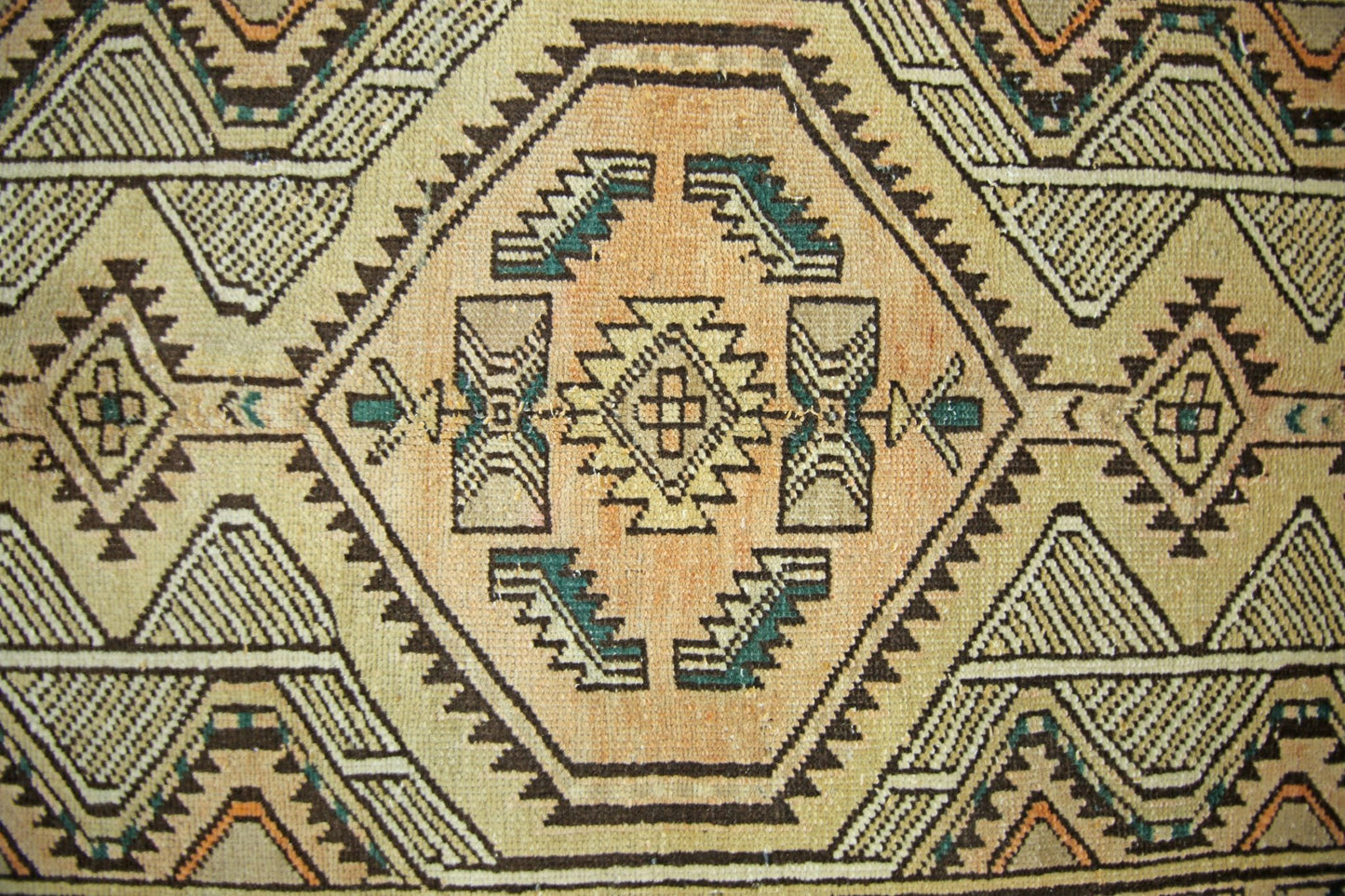 A vintage Persian Serab runner featuring a geometric pattern in tan, brown, and teal wool.