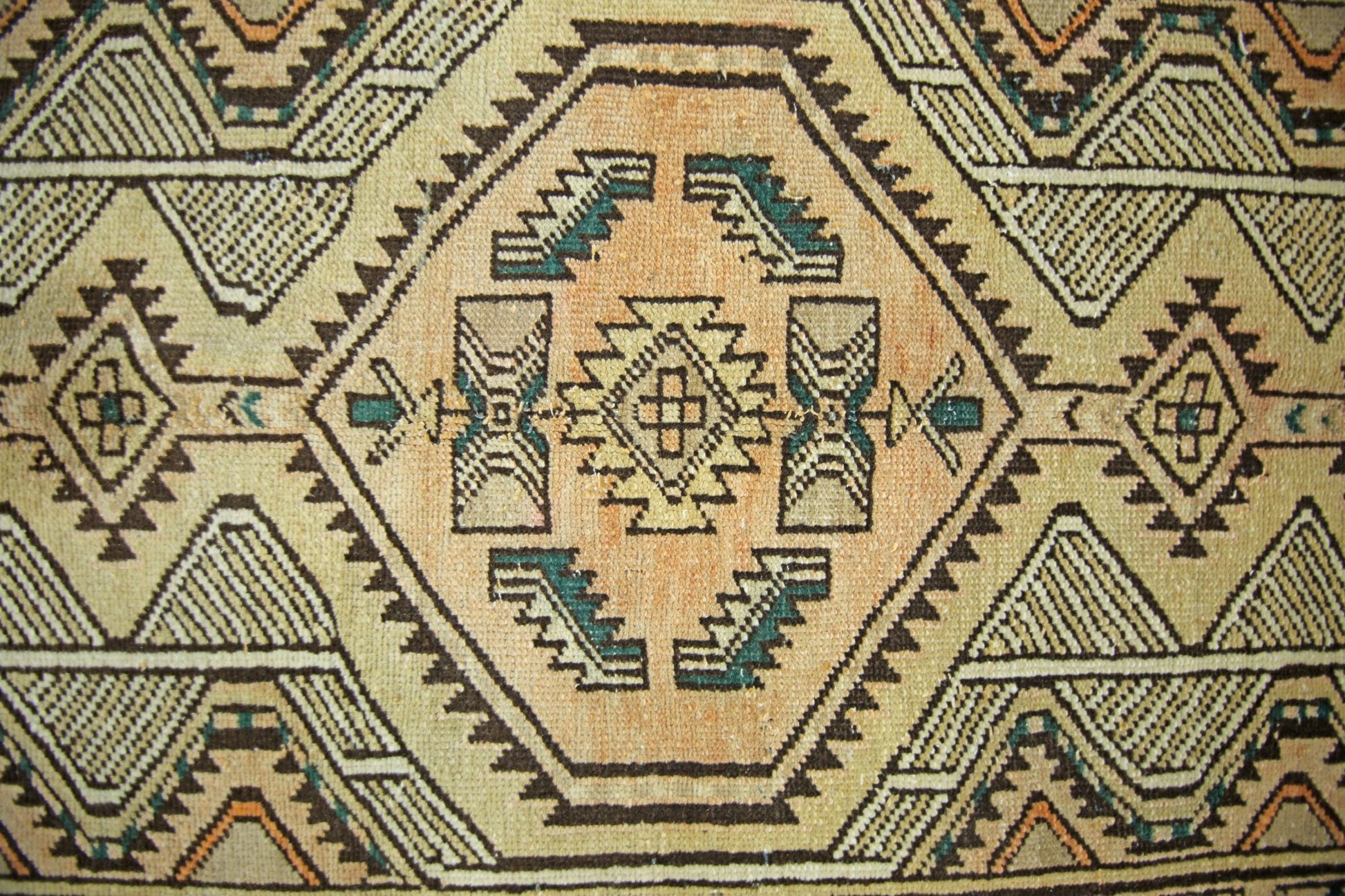 A vintage Persian Serab runner featuring a geometric pattern in tan, brown, and teal wool.