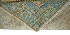 A corner of a vintage Persian Serab runner showing a blue and beige geometric pattern.
