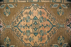 A vintage Persian Serab runner featuring a geometric diamond medallion in muted earth tones.