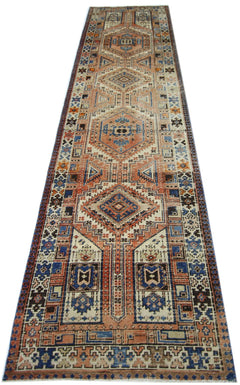 A vintage Persian Serab runner featuring geometric patterns in shades of blue, orange, and cream.