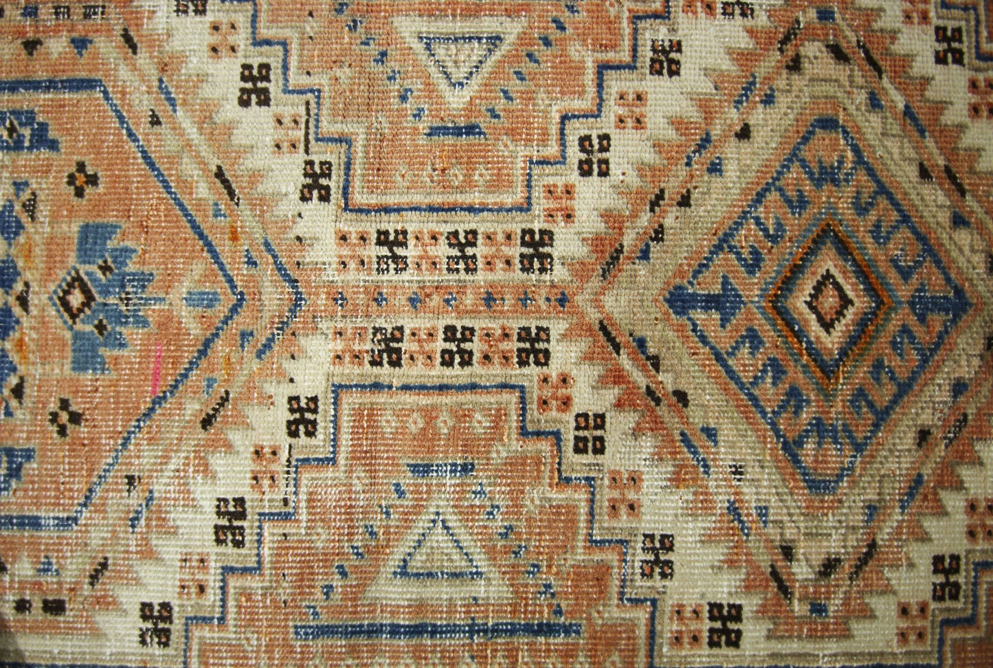 A vintage Persian Serab runner featuring geometric diamond patterns in blue, tan, and cream.