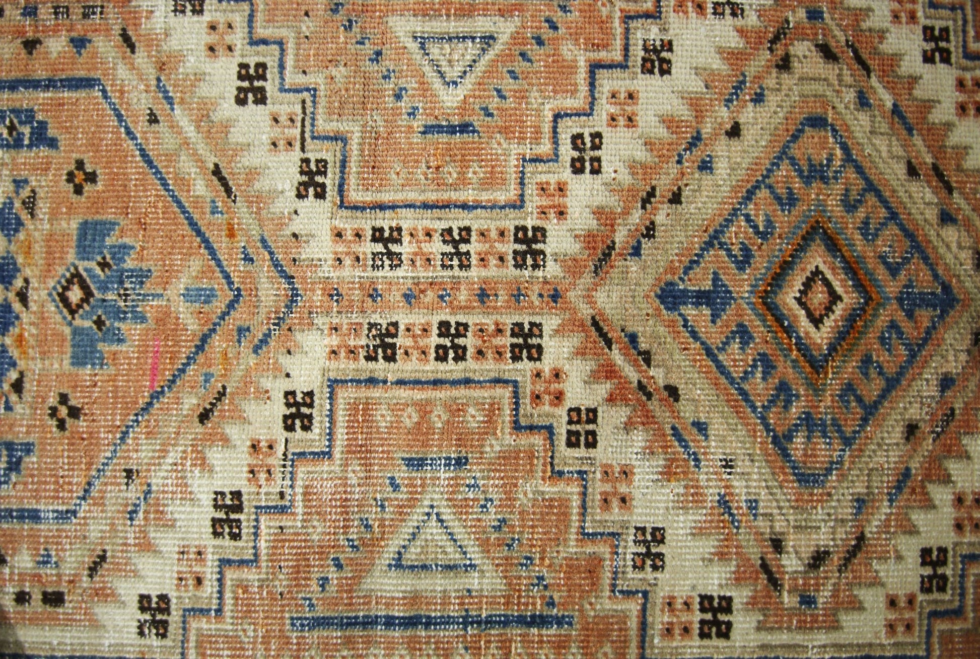 A vintage Persian Serab runner featuring geometric diamond patterns in blue, tan, and cream.