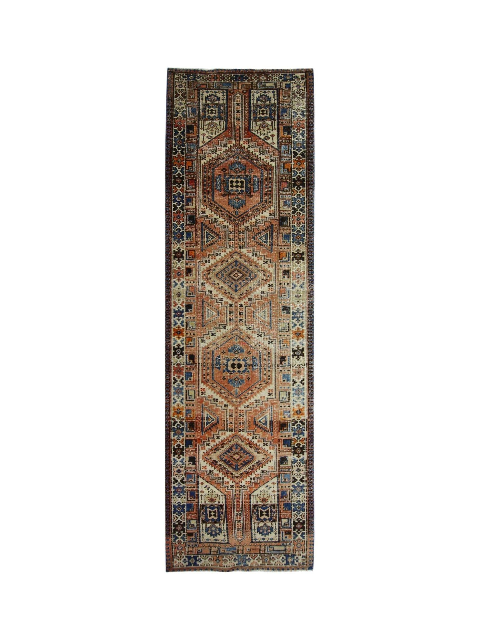 A vintage Persian Serab runner featuring geometric medallions in rust, blue, and cream tones.