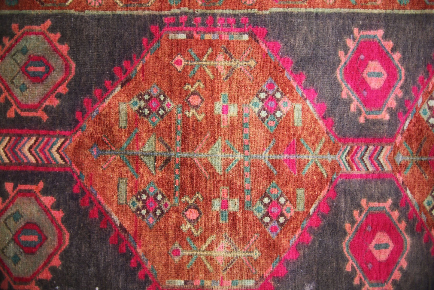 A vintage Persian Hamadan runner featuring a central orange diamond medallion on a dark field.