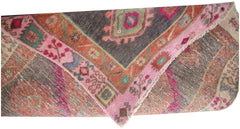 A vintage Persian Hamadan runner featuring a geometric pattern in pink, orange, and dark grey.