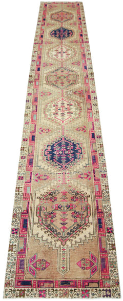 A vintage Persian Hamadan runner featuring geometric medallions in pink and blue on a tan field.