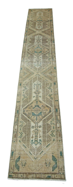 A vintage Persian Serab runner rug featuring geometric patterns in muted blue and brown tones.
