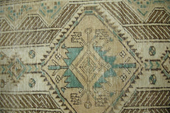 A vintage Persian Serab runner featuring a geometric diamond medallion in teal and brown tones.