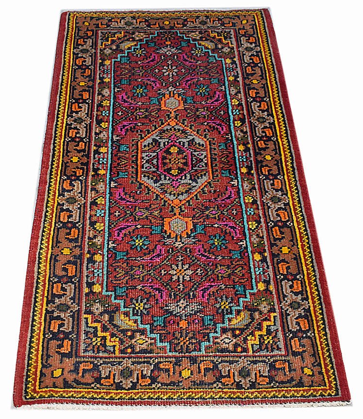 A handwoven vintage Persian Shiraz rug featuring a geometric medallion pattern in red and blue.