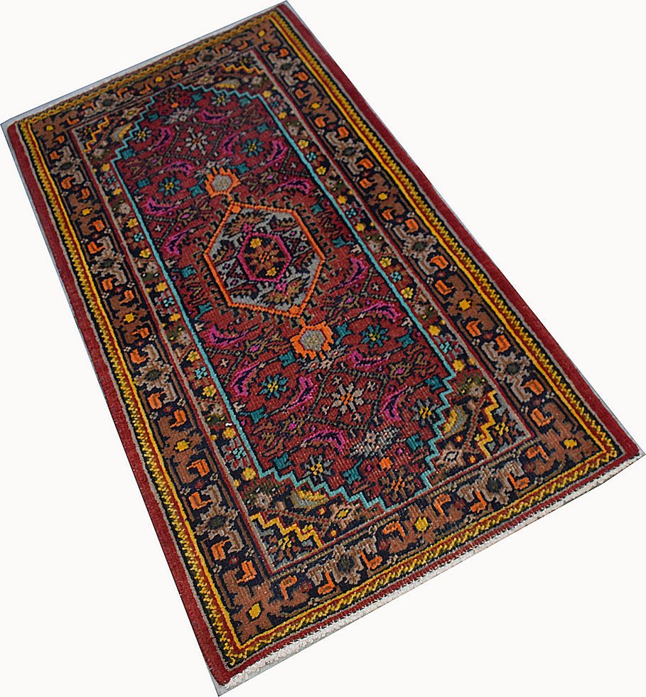 A rectangular vintage Persian Shiraz rug featuring a geometric pattern in red, blue, and orange.