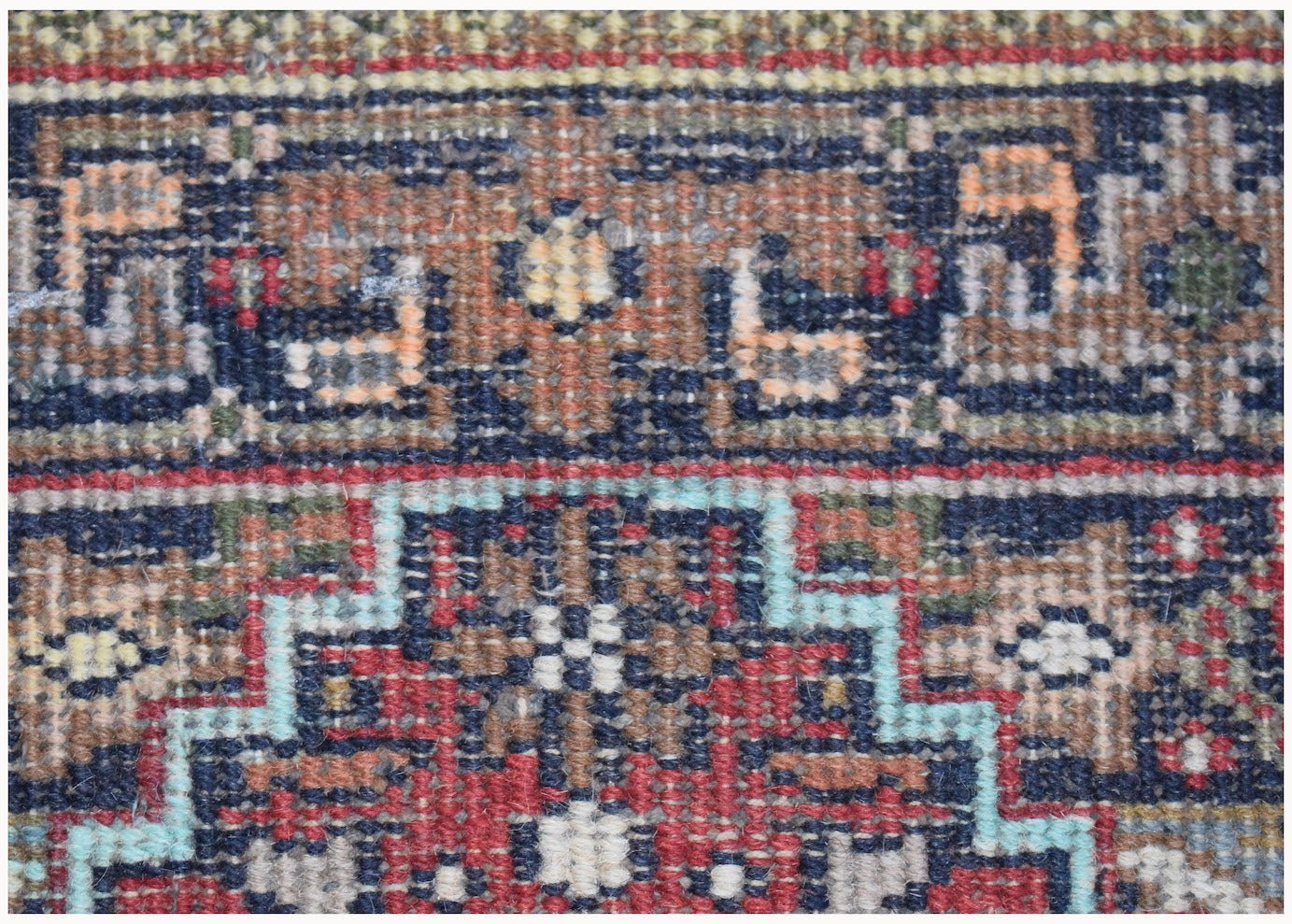 A close-up of a vintage Persian Shiraz rug featuring intricate geometric patterns in wool.