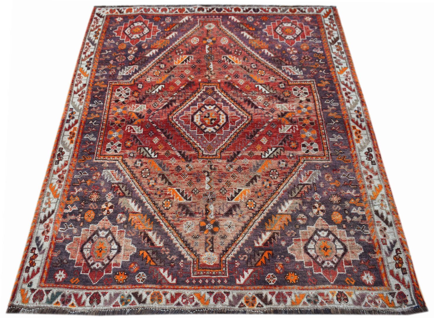 A vintage handwoven Persian Shiraz rug featuring a geometric diamond pattern in red and purple.