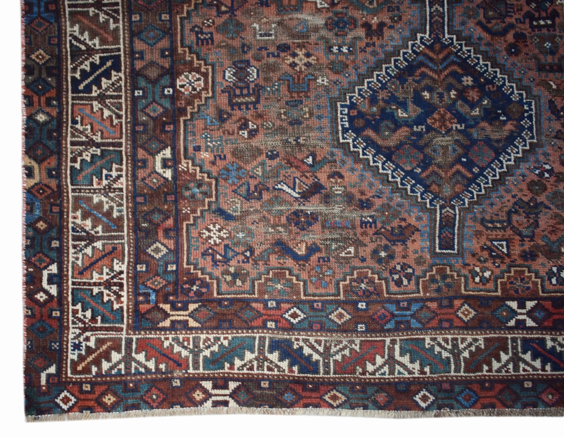 A vintage handwoven Persian Shiraz rug featuring a geometric pattern in red, blue, and brown.
