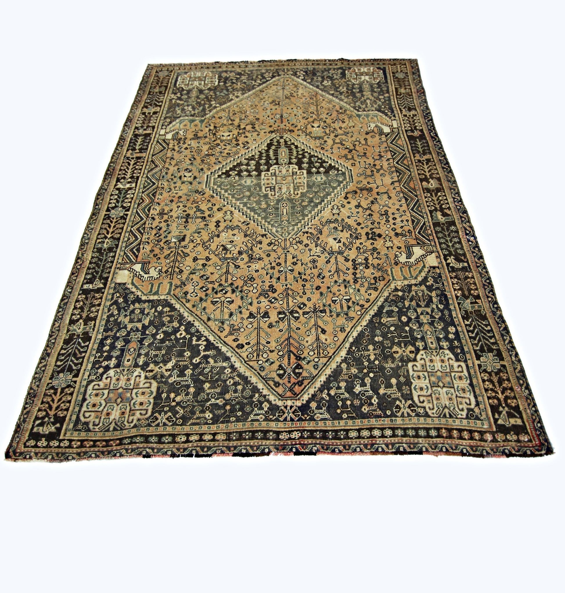 A vintage handmade Persian Shiraz rug featuring a central diamond medallion on a tan and dark field.