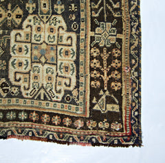 A vintage Persian Shiraz rug featuring a geometric central medallion and intricate floral borders.