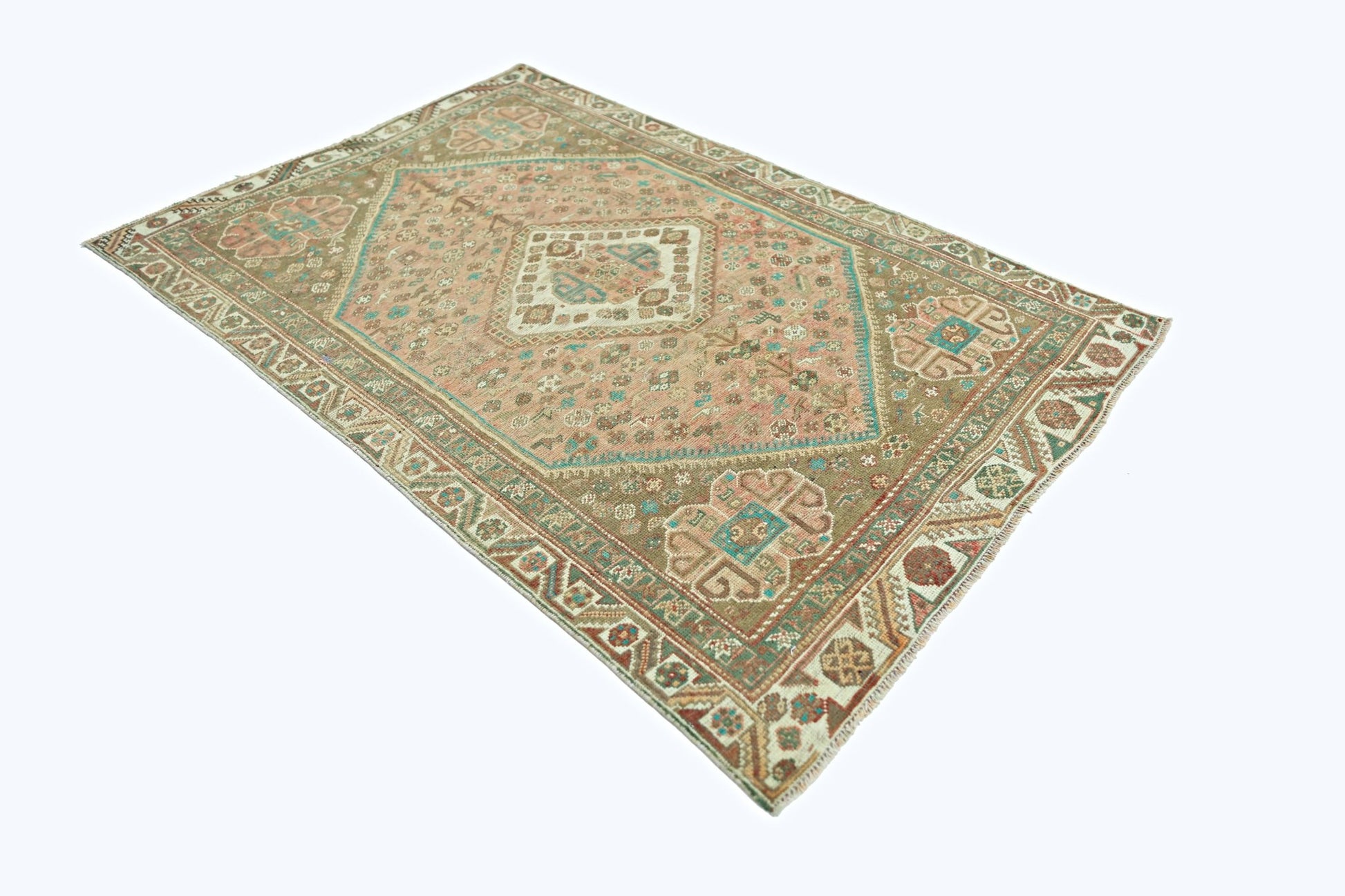 A vintage Persian Shiraz rug featuring a geometric diamond medallion in muted pink and brown tones.