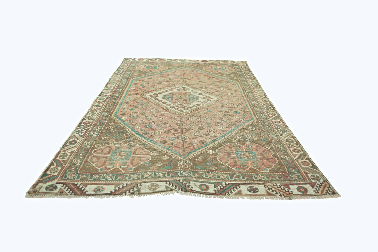 A vintage Persian Shiraz rug featuring a central diamond medallion on a muted pink and brown field.