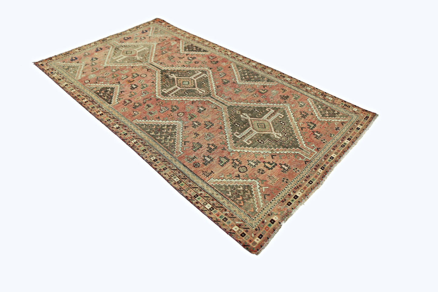 A vintage Persian Shiraz rug featuring a geometric diamond pattern in muted red and brown tones.
