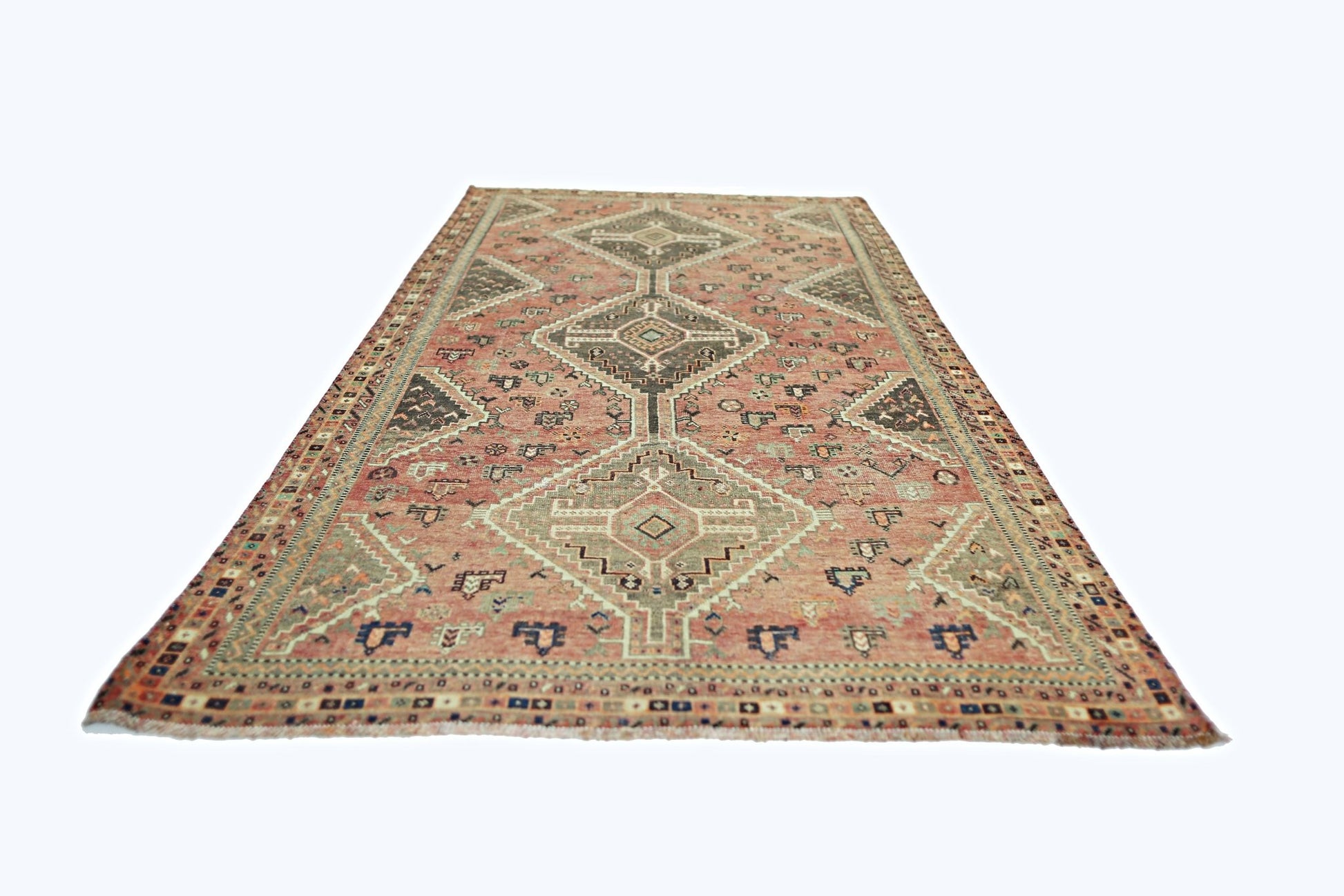 A vintage Persian Shiraz rug featuring geometric diamond patterns in muted red and earthy tones.