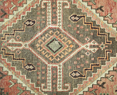 A vintage Persian Shiraz rug featuring a geometric diamond medallion in brown, red, and cream.