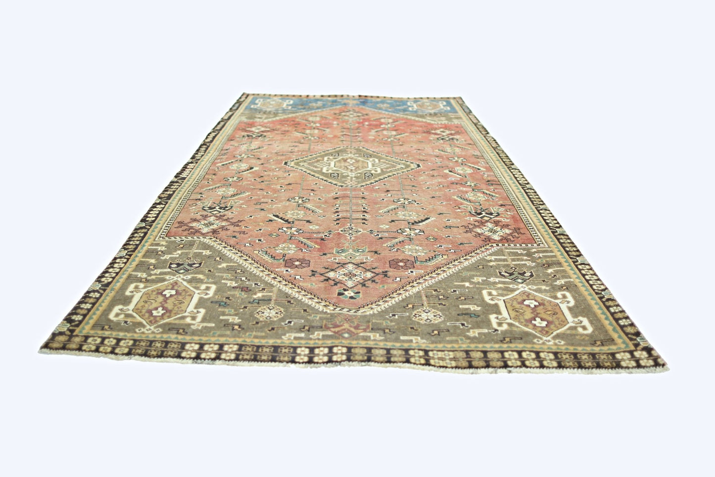 A vintage Persian Shiraz rug featuring a geometric medallion pattern in muted red and brown tones.