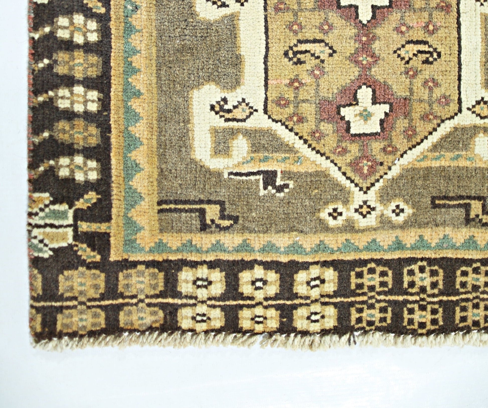 A vintage Persian Shiraz rug featuring a geometric pattern in brown, tan, and cream tones.