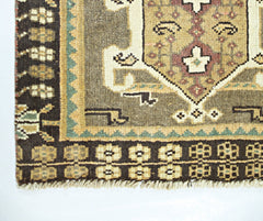 A vintage Persian Shiraz rug featuring a geometric pattern in brown, tan, and cream tones.