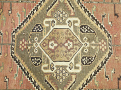 A vintage Persian Shiraz rug featuring a central geometric medallion in olive and terracotta tones.