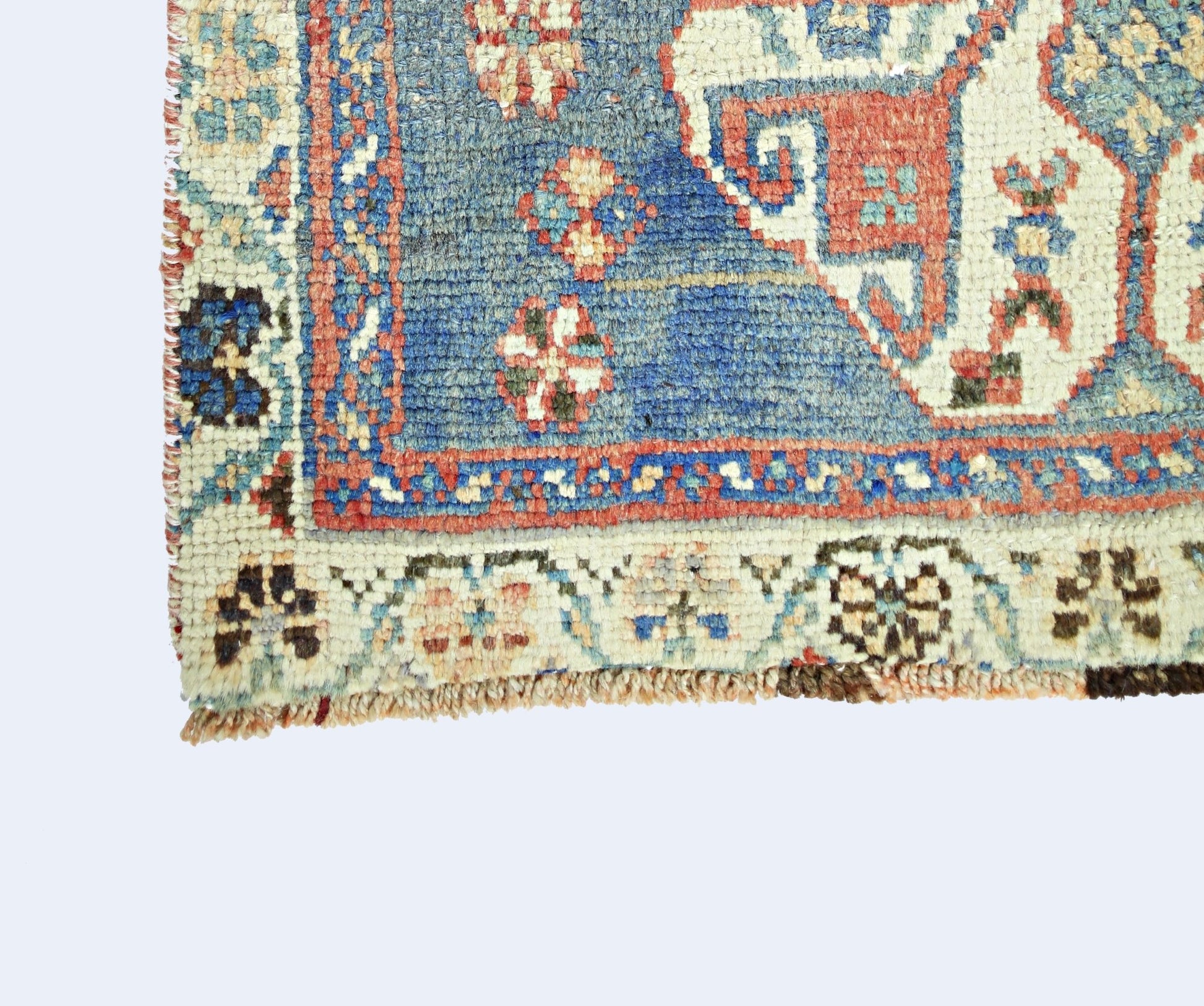 A corner detail of a vintage Persian Shiraz rug featuring intricate geometric patterns in wool.