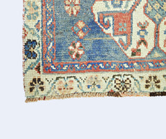 A corner detail of a vintage Persian Shiraz rug featuring intricate geometric patterns in wool.