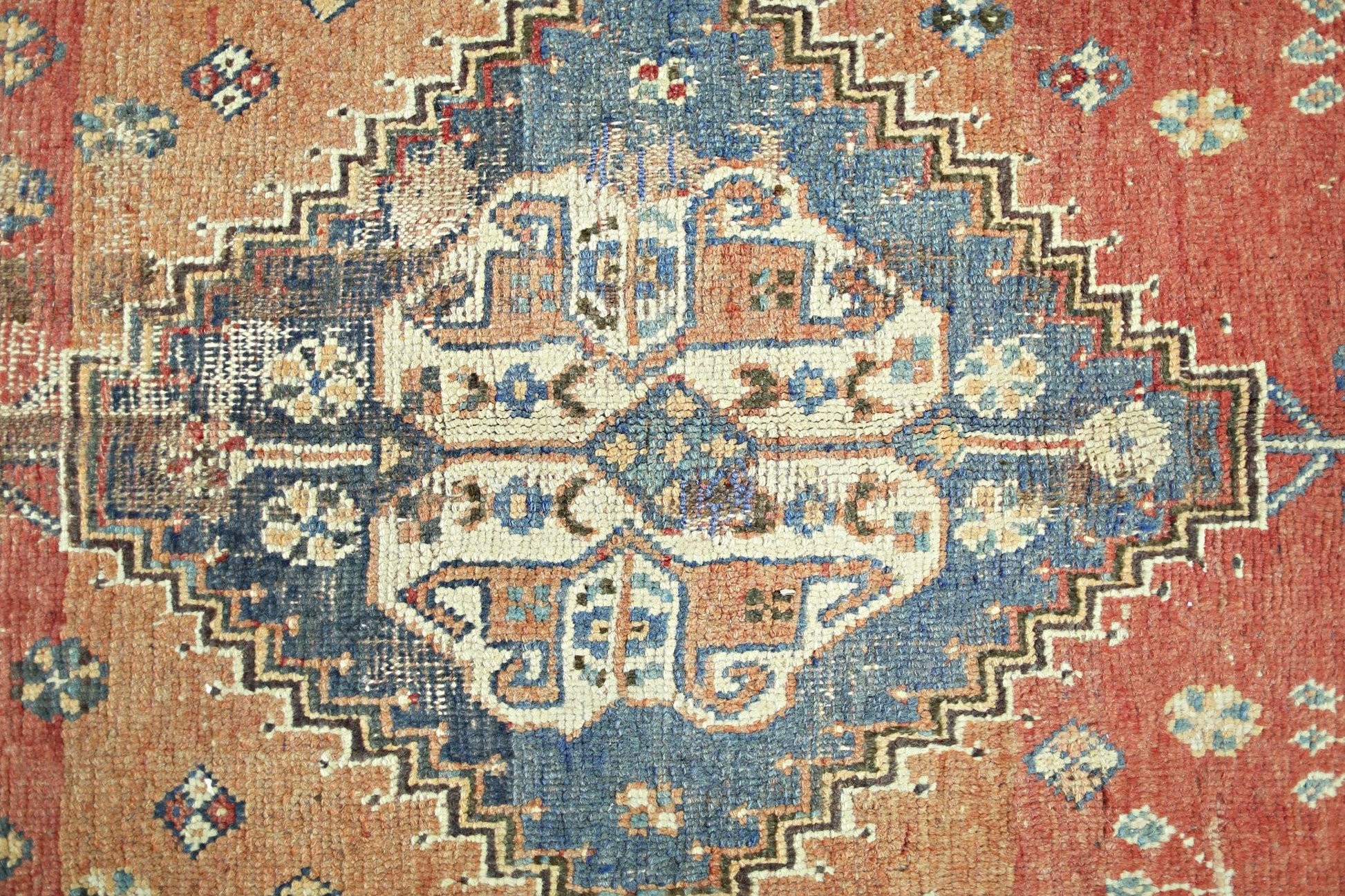 A vintage Persian Shiraz rug featuring a central blue diamond medallion on a red field.