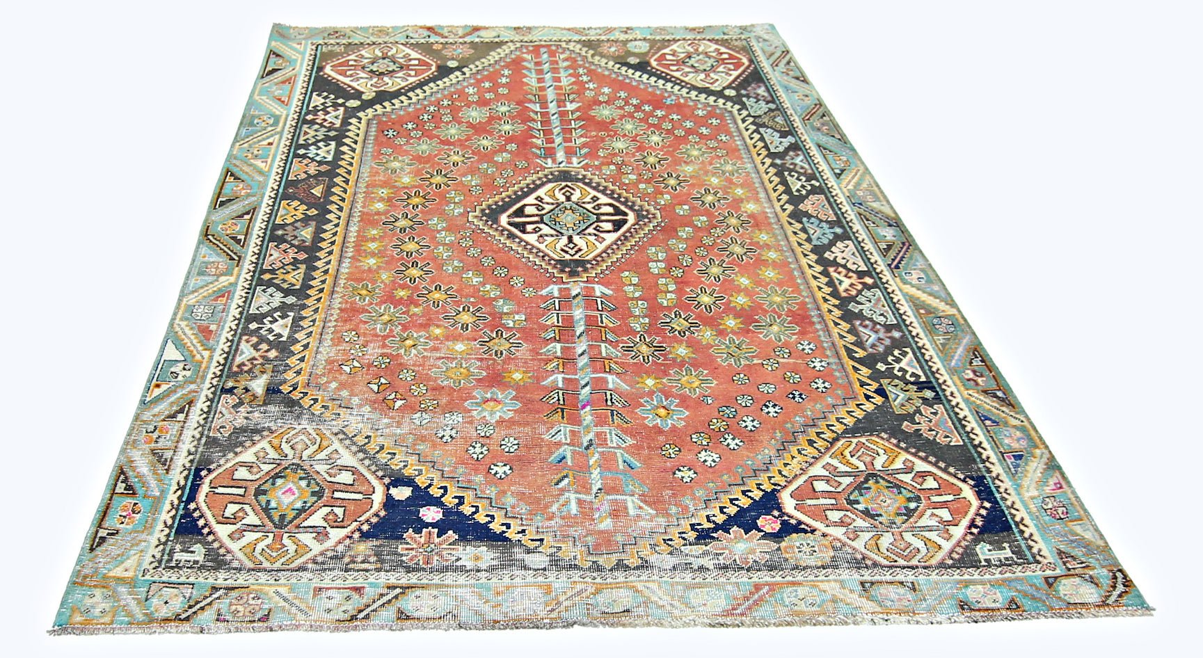 A vintage handmade Persian Shiraz rug featuring a geometric red field with blue and cream accents.