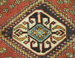 A vintage Persian Shiraz rug featuring a central geometric diamond medallion on a red field.