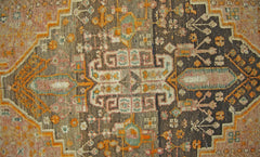 A vintage Persian Shiraz rug featuring intricate geometric patterns in muted earth tones.