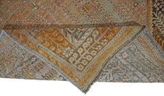 A corner of a vintage Persian Shiraz rug is folded over to show its intricate floral pattern.