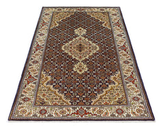 A vintage Persian Tabriz rug featuring an intricate floral medallion pattern in deep red and cream.