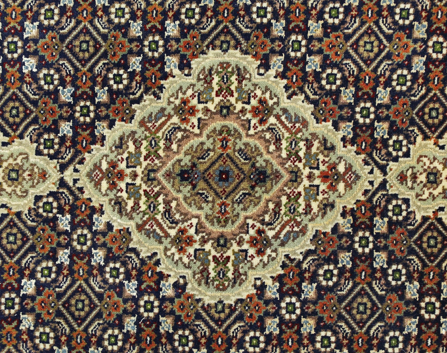 A vintage Persian Tabriz rug featuring an intricate floral medallion pattern in silk and wool.
