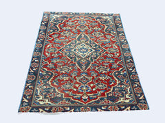 A rectangular vintage Persian rug featuring a traditional floral pattern in red and blue tones.