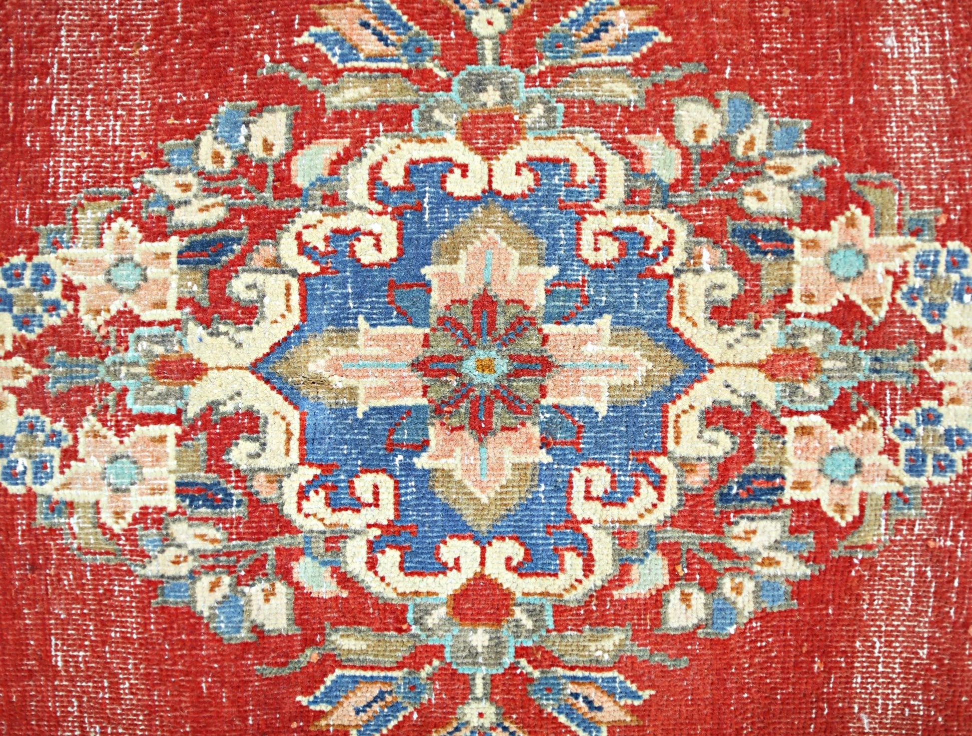 A vintage Persian Tabriz rug featuring a central floral medallion in blue, red, and cream tones.