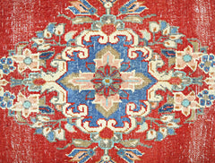 A vintage Persian Tabriz rug featuring a central floral medallion in blue, red, and cream tones.