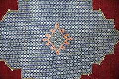 A vintage Persian rug featuring a blue field with a repeating floral pattern and a central diamond.