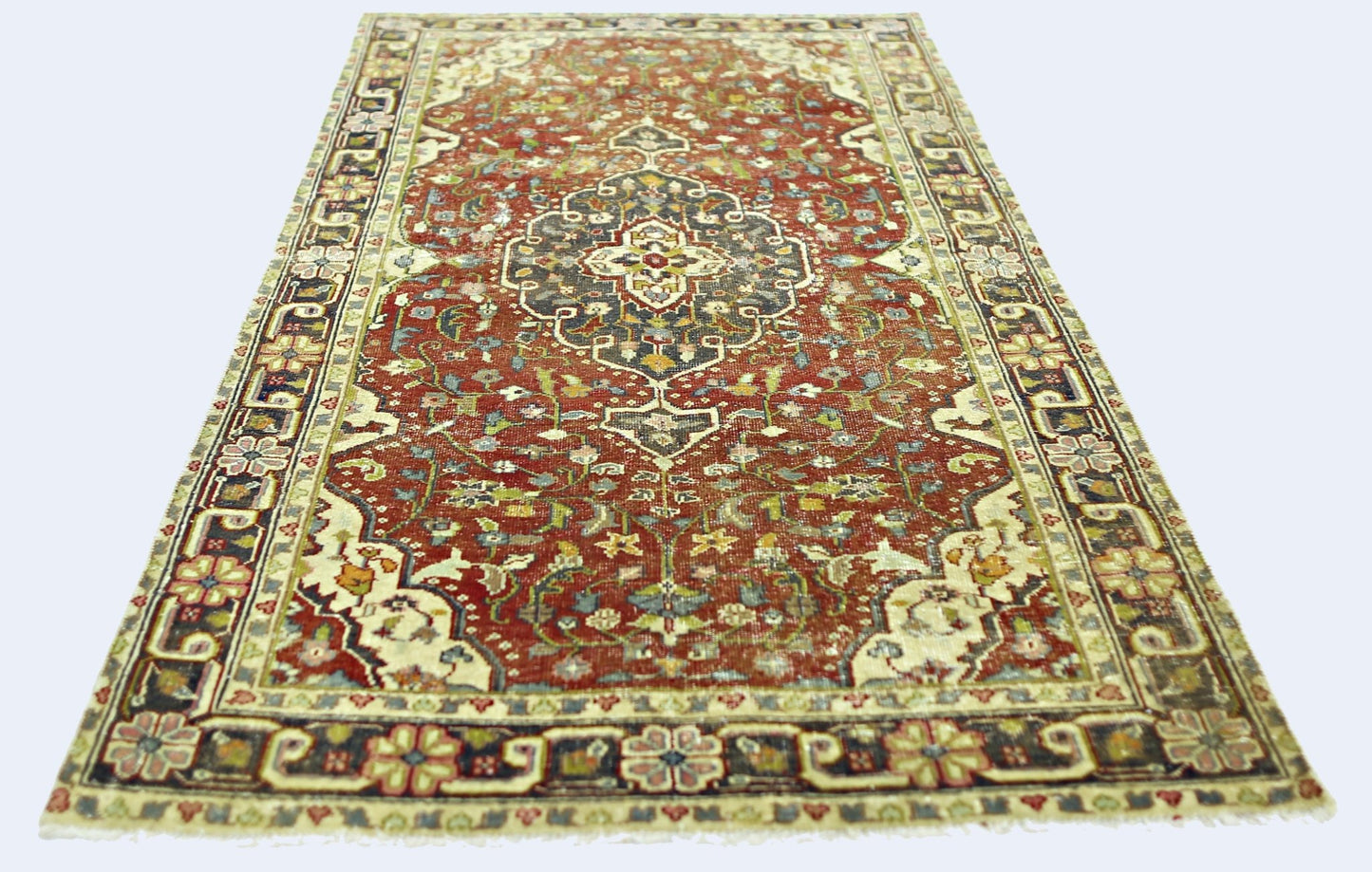A rectangular vintage Persian rug featuring a central medallion on a red field with floral patterns.
