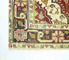 A corner view of a handmade vintage Persian rug featuring intricate floral patterns in red and blue.