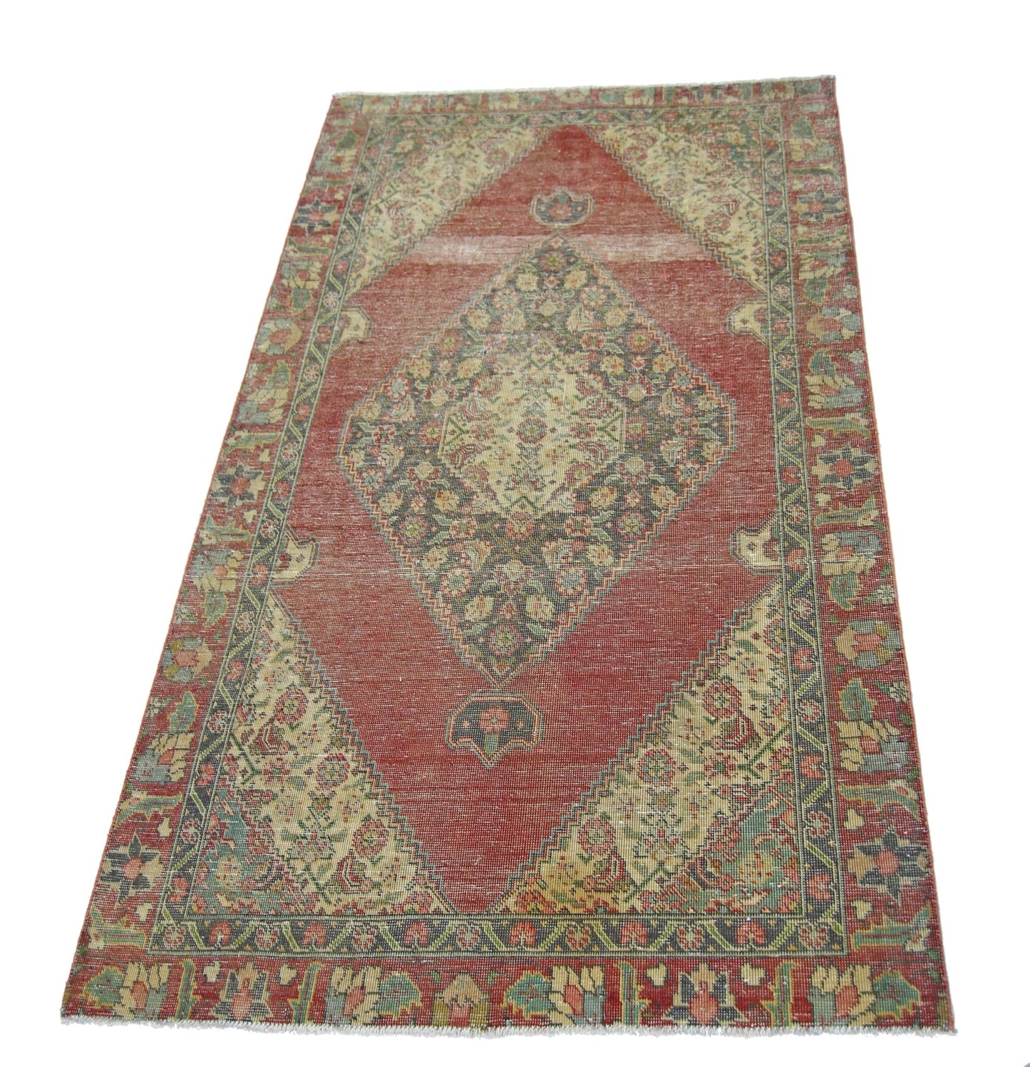 A vintage handmade Persian rug featuring a central diamond medallion on a red field.